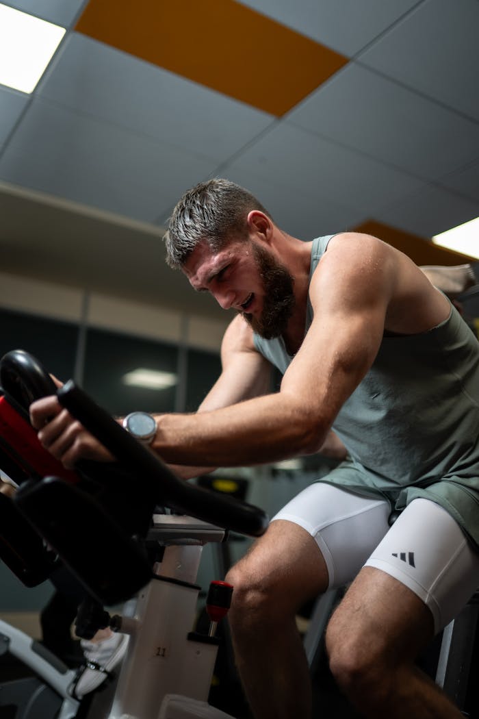 Man engaged in focused indoor cycling session showcasing fitness and determination.