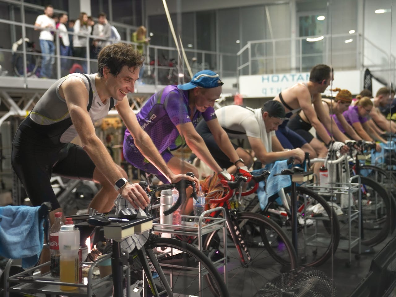 Group of cyclists participating in an indoor cycling session, focused on training and fitness.
