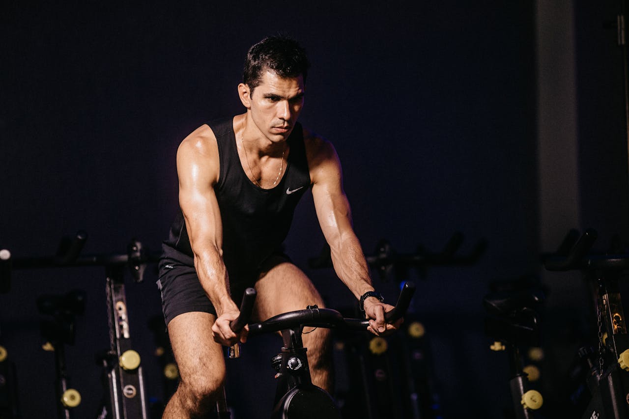 Focused man engaging in a vigorous indoor cycling session, showcasing fitness and determination.